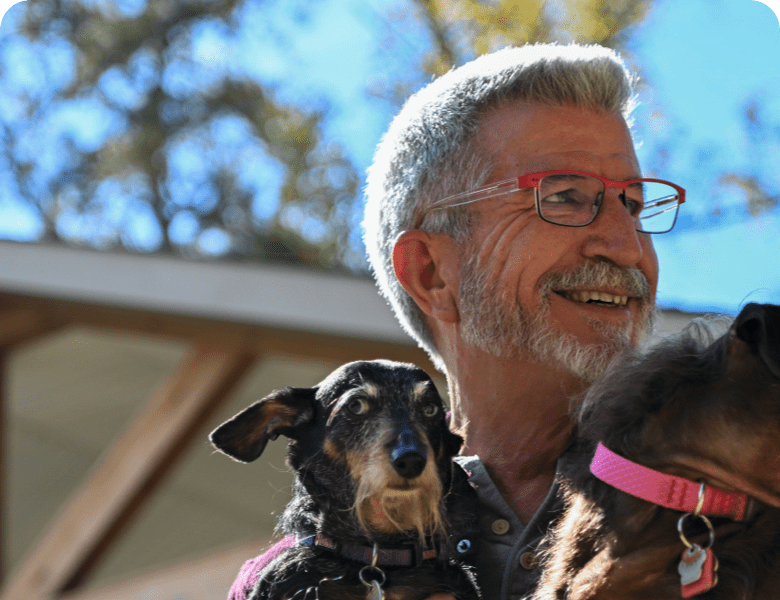 Theron holding 2 dogs.