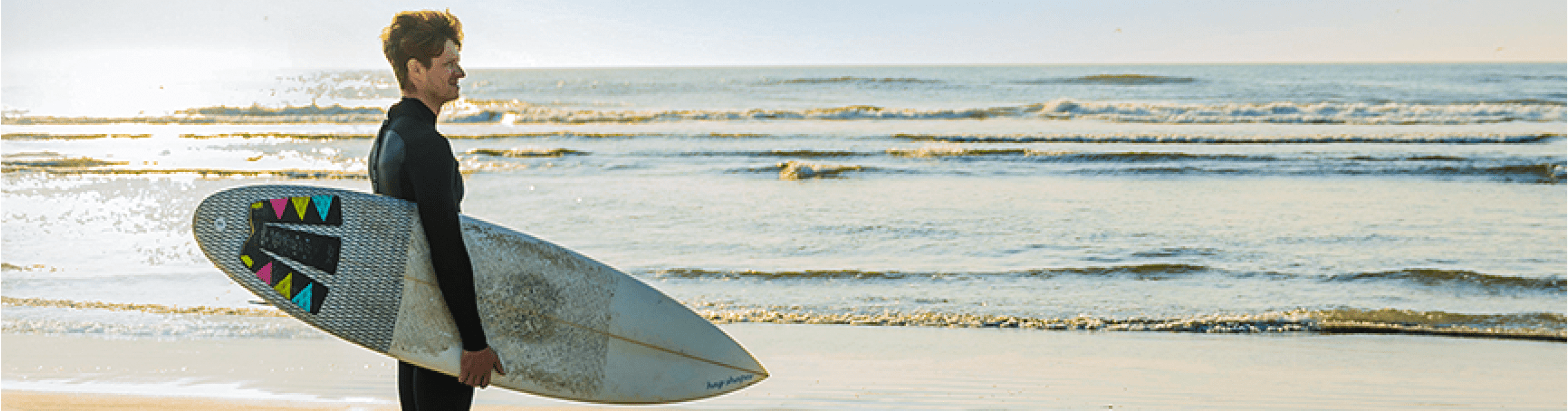 Zach is holding a surfboard.